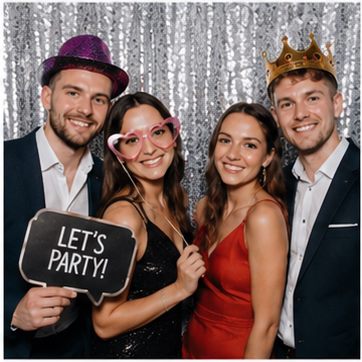 Vier Gäste mit Partyhut und Krone feiern Geburtstag