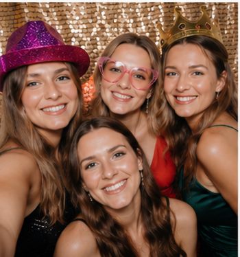 Gruppen-Selfie mit Krone und Partyhut vor Goldpailletten